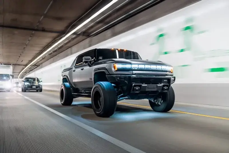 Lifted electric Hummer truck speeds through tunnel with LED lights glowing